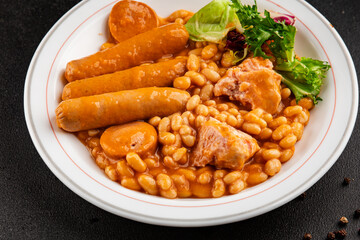 Casule meat with beans in sauce sausages, pork main course tasty snack fresh delicious gourmet food table background rustic food top view copy space