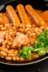 Casule meat with beans in sauce sausages, pork main course tasty snack fresh delicious gourmet food table background rustic food top view copy space