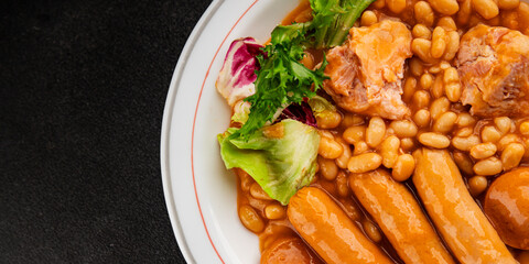 Casule meat with beans in sauce sausages, pork main course tasty snack fresh delicious gourmet food table background rustic food top view copy space