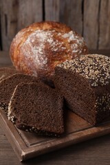 Different types of bread on wooden table, closeup
