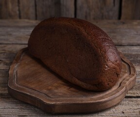 Delicious fresh rye bread loaf on wooden table, closeup