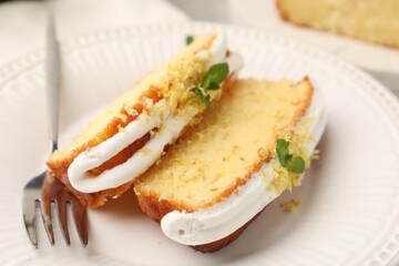 Delicious lemon cake with glaze, fresh fruit slices and mint served on table, closeup