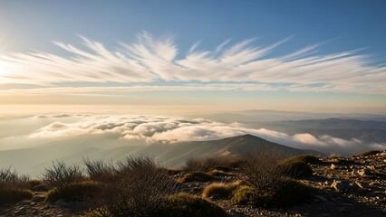 Majestic Mountain Peak Above Clouds at Golden Hour with Dramatic Cirrus Sky.
