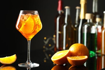 Refreshing spritzer cocktail and orange slices on table in bar. Space for text