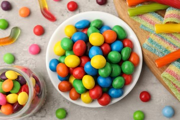 Delicious colorful candies on light table, flat lay