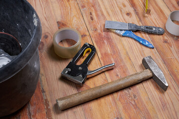 Working tools for repairs on a wooden floor.