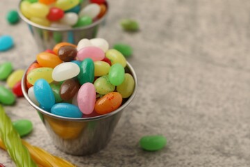 Delicious colorful candies on grey table, closeup. Space for text