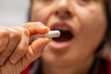 A woman who takes medication when she is sick. Excessive medication use negatively affects health.