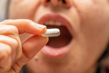 A woman who takes medication when she is sick. Excessive medication use negatively affects health.
