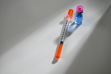 Close up of Single Use Syringe Next to Glass Vial with Blue Liquid of Copper Peptides