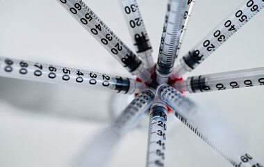 Multiple Single Use Syringes Injected Into Glass Vial with red Top