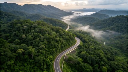 Aerial perspective of a winding asphalt highway cutting through dense emerald rainforest, dramatic serpentine curves climbing toward mist-covered highlands; lush tropical canopy, vibrant biodiversity,