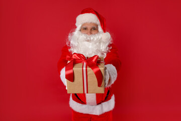 Santa Claus with Christmas gift on red background