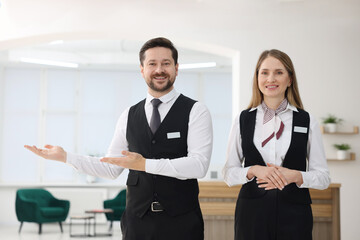 Receptionist and hostess near reception desk indoors
