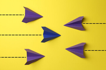 Paper planes with dotted lines as air route track on yellow background
