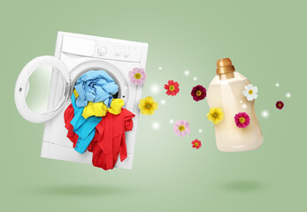 Bottle of laundry detergent or fabric softener with floral scent and washing machine on sage green background