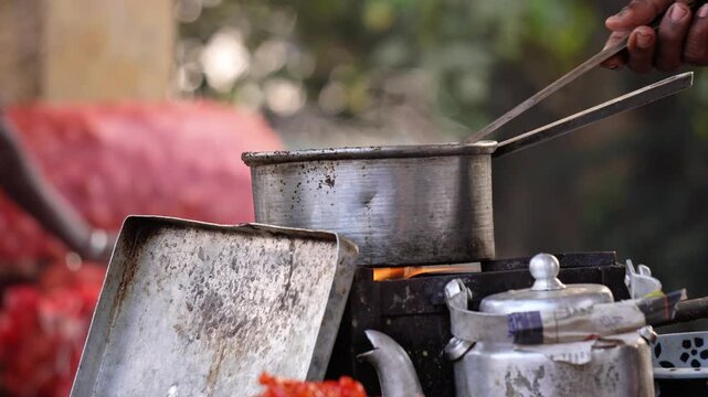 An Indian tea stall making tea for customers in a indian market.