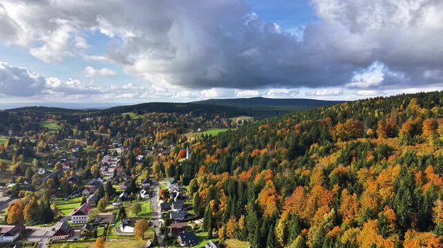 Village Nestled In Autumn Valley Panorama, Rooftops Among Colorful Trees, Winding Roads, Dramatic Cloudscape,