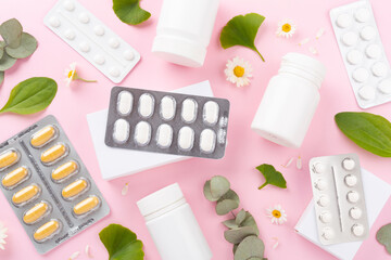 Herbs and flowers with medicines on color background, top view