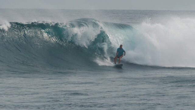 Surfer rides the big wave in the Maldives