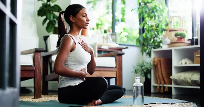 Breathing, lotus pose and woman in home in morning for relax, calm or yoga exercise for balance. Wellness, healing and person with chakra alignment for spiritual meditation in living room at house.
