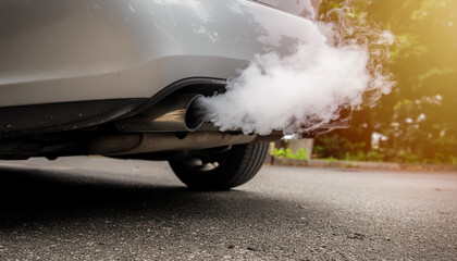 White Smoke Emitting from Car Exhaust on a City Road in Warm Morning Light