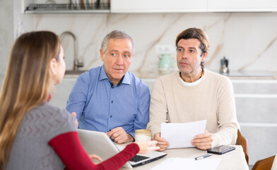 Fototapeta premium Elderly man and adult man discussing deal with seller in kitchen