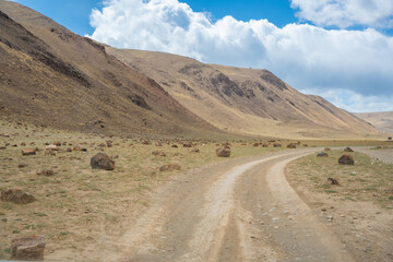Gravel road through deserted valley leading to Mars Altai Russia. Remote pathway to famous colorful geological landmark.