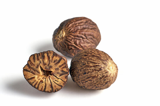 three dried aromatic nutmegs isolated on white background.