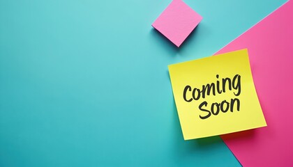 Yellow sticky note with Coming Soon text on bright teal background. Pink paper pieces add contrast. Anticipation for new product launch or event announcement.