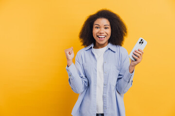 African American woman celebrating mobile phone winning success