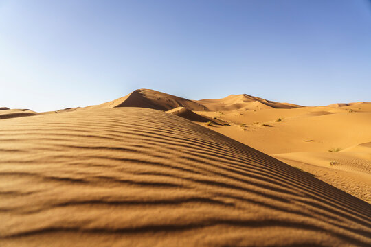 dune de sable en gros plan, ondulation &agrave; la surface et grandes dunes au loin