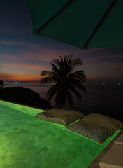 View from luxury villa at dusk, pool lighting, sun loungers for sunbathing, umbrellas from the sun, pillows for swimming in the pool, palm tree on background