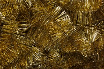 Holiday background with shiny golden Christmas garlands. Christmas background with Christmas tinsel and copy space