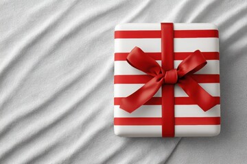 Striped wrapping paper gift box tied with a red ribbon, placed on a soft textured surface, embodying the festive spirit of New Year and Christmas celebrations with copy space