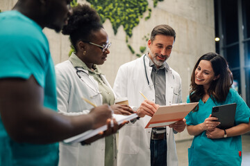 Medical team collaborating discussing patient records in hospital