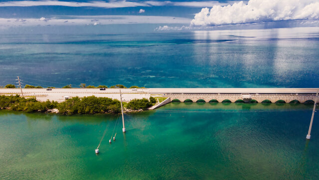 Long coastal bridge linking islands above clear tropical ocean near Key West - Powered by Adobe