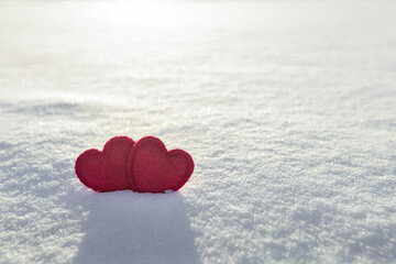two red hearts on white fresh snow, love heart concept, valentine's day card,