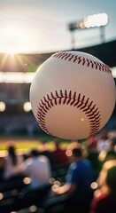 White stitched baseball suspended midair over a lively outdoor stadium during a vibrant sunset sporting event, with numerous enthusiastic fans enjoying the exciting match.