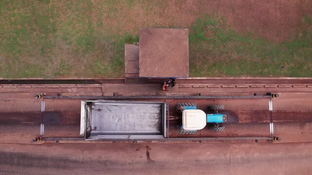 Aerial shot of empty tractor on a weighing bridge in a factory