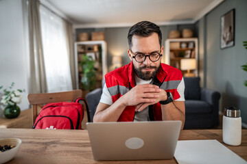 Paramedic working from home using telemedicine on laptop