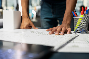 Middle eastern property contractor studying blueprints design for a future residential building project, architectural plans for a new housing initiative focused on innovation and market demand.