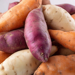 Close-up shot of sweet potatoes highlighting rough skin details and rich color. Perfect for recipe blogs, vegetable packaging, nutrition visuals, and clean culinary photography.