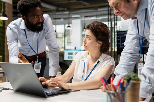 Colleagues in multinational company working together at laptop, having meeting on financial budget. African american and caucasian marketing analysts teamworking to improve business project plans. - Powered by Adobe