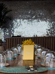 table setting in the restaurant, a sign saying reserved on the table, yellow flowers, glasses turned upside down waiting for guests
