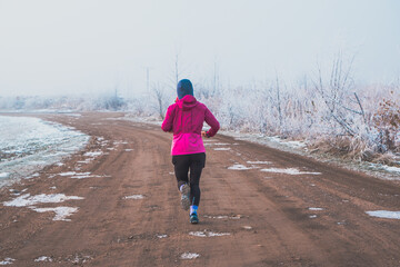 woman jogging on a gravel path in winter
