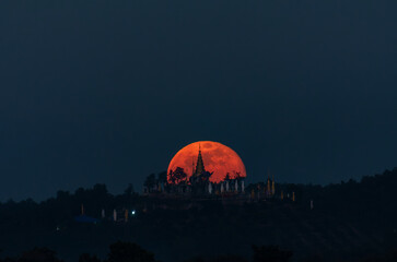 The moon rises behind Phra That Nang Khoi, Chiang Rai, northern Thailand.