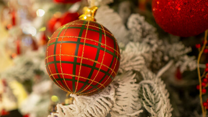 Red Christmas toys are hanging on the Christmas tree.