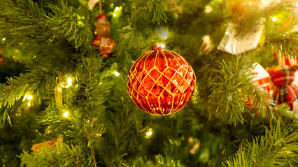 Red Christmas toys are hanging on the Christmas tree.