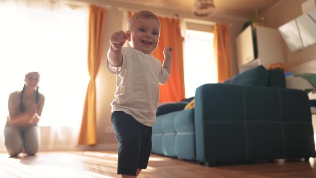 Baby is taking the first steps. happy family kid dream concept. Mom and baby taking the first steps. family together Mom taking the first steps with her baby toddler. fun first steps concept.